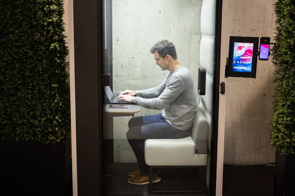 A professional working on a laptop inside a Quiet Corner Focus pod at the Javits Center